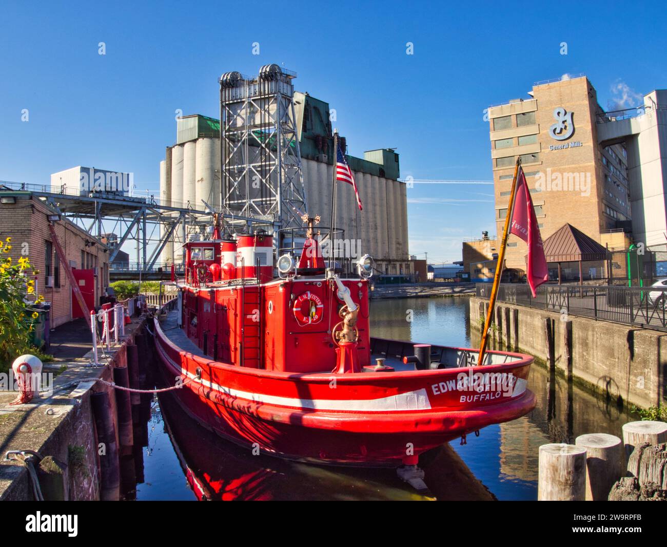 Edward M. Cotter fireboat anchored in Buffalo, NY, in front of General Mills factory and industrial waterfront of Buffalo. Stock Photo