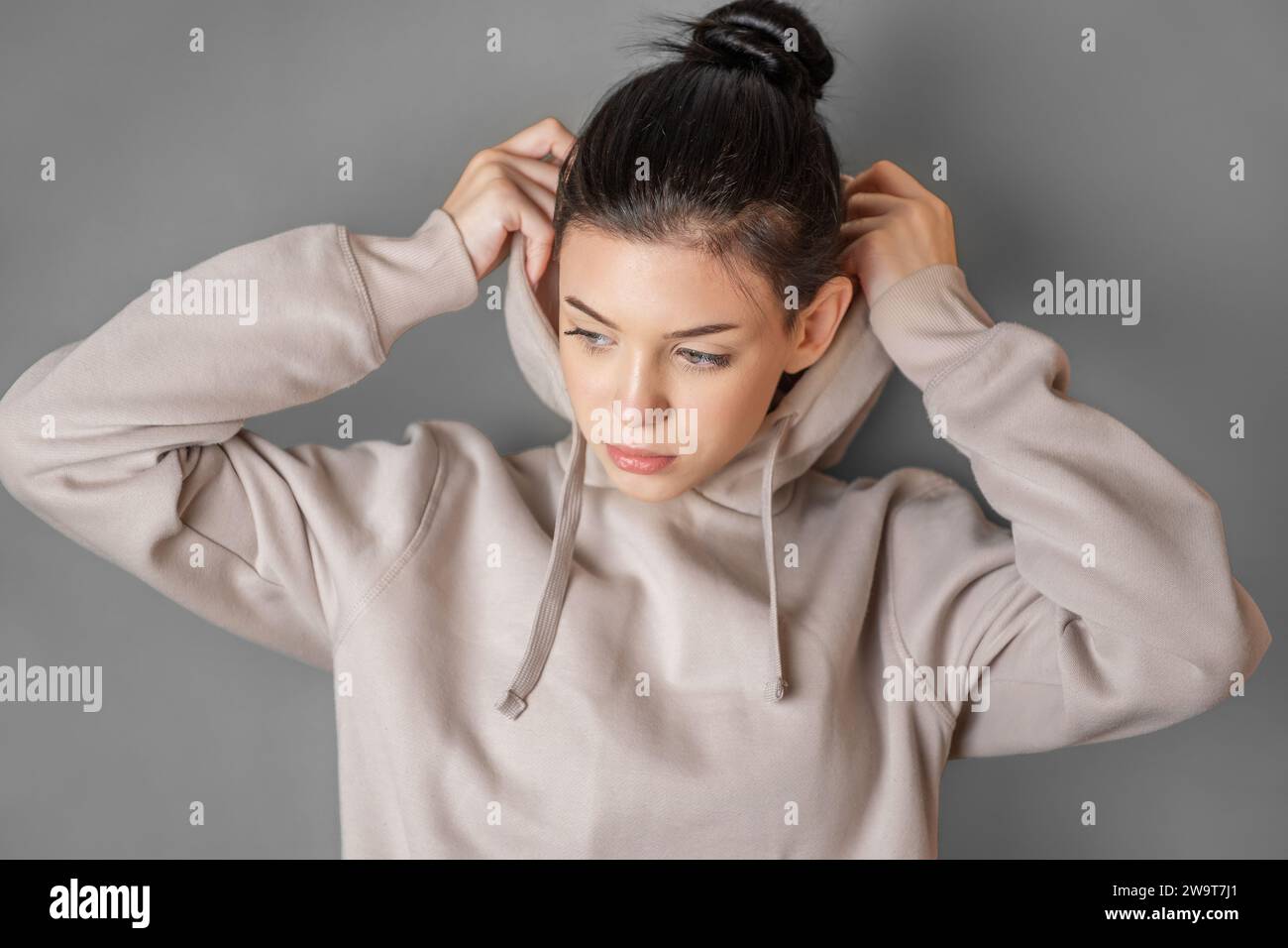 Pensive thoughtful teenager girl wearing sweatshirt with hood Stock Photo