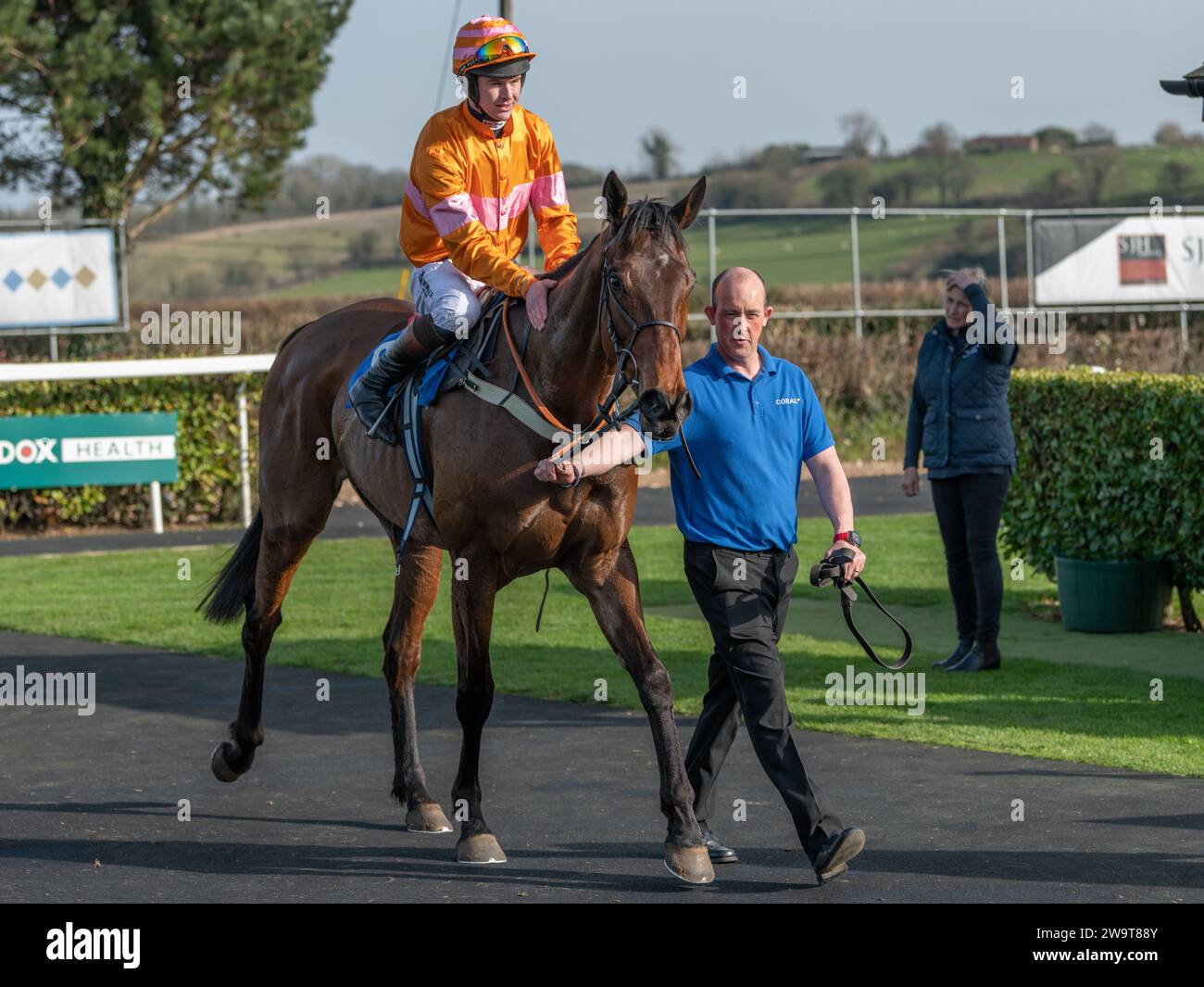 Name in Lights with jockey Brendan Powell and groom Richie in winner's position in the post race parade for the fourth race at Wincanton, March 21st 2 Stock Photo