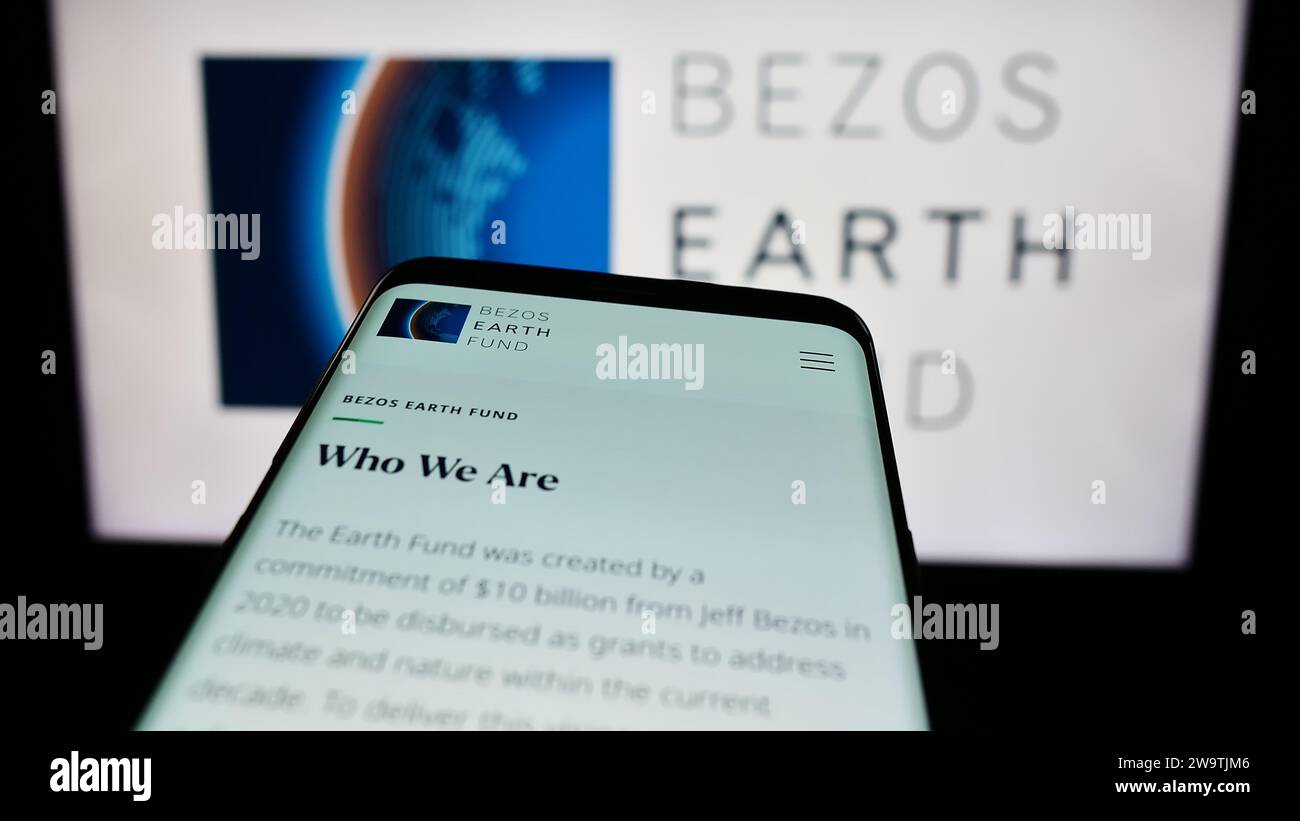 Mobile phone with website of environmental organization Bezos Earth Fund in front of logo. Focus on top-left of phone display. Stock Photo