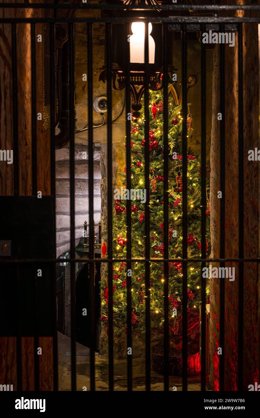 Christmas tree in alley off Royal Mile lit up at night with old fashioned street lamp, Edinburgh, Scotland, UK Stock Photo