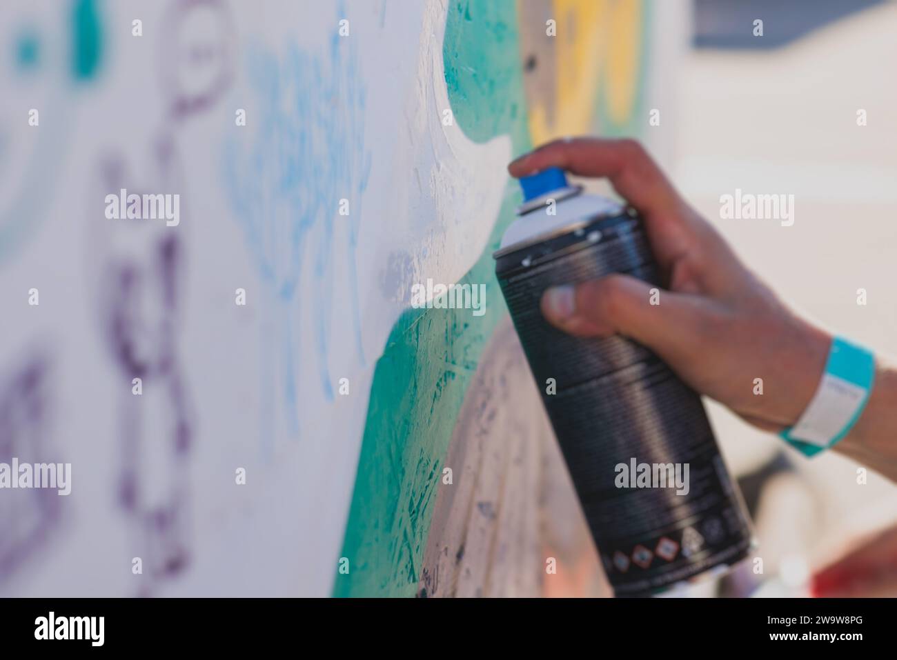 Process of creating graffiti, street artist with aerosol spray paint ...