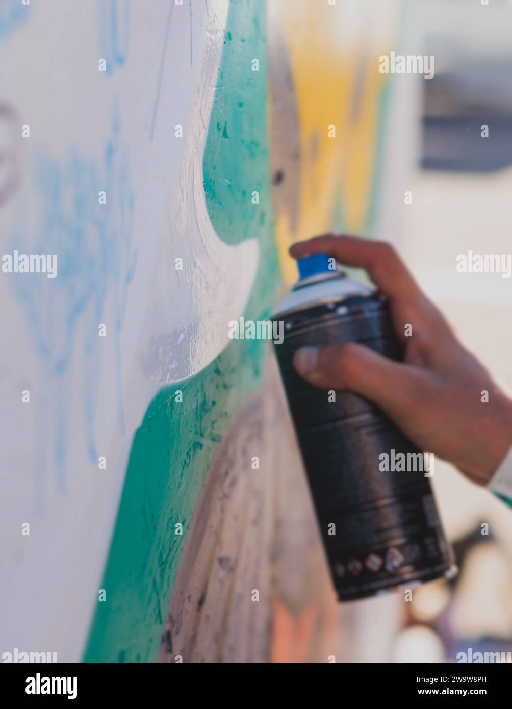 Process of creating graffiti, street artist with aerosol spray paint ...