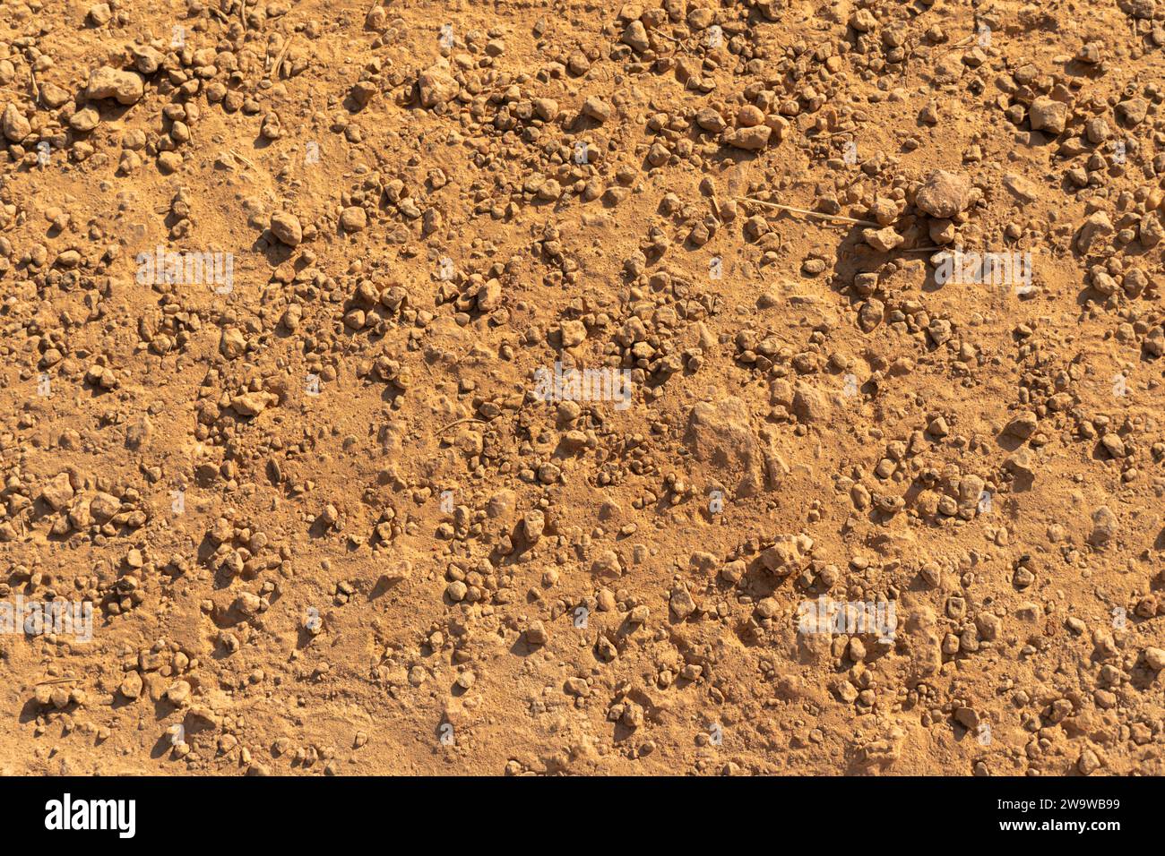 Stony ground texture background. Red Soil Tropical laterite soil or red earth background. Red earth or soil background. Tropical laterite soil backgro Stock Photo