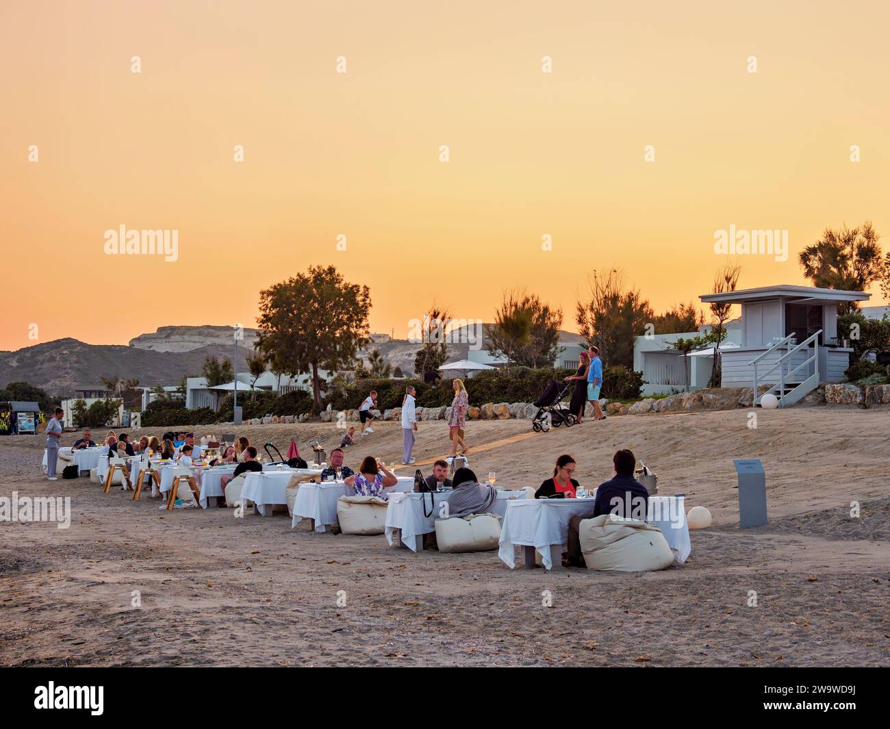 People eating al fresco at Agios Stefanos Beach, dusk, Kos Island, Dodecanese, Greece Stock Photo