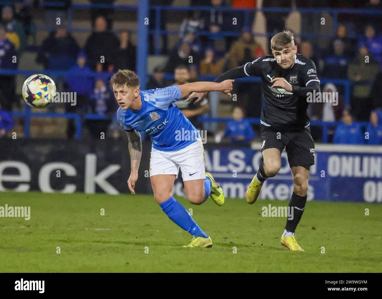 Mourneview Park, Lurgan, County Armagh, Northern Ireland, UK. 30th Dec 2023. Sports Direct Premiership – Glenavon v Ballymena United Action from today's game at Mourneview Park (Glenavon in blue). Glenavon's Matthew Snoddy and Ballymena's Ryan Waide battle for possession. Credit: CAZIMB/Alamy Live News. Stock Photo