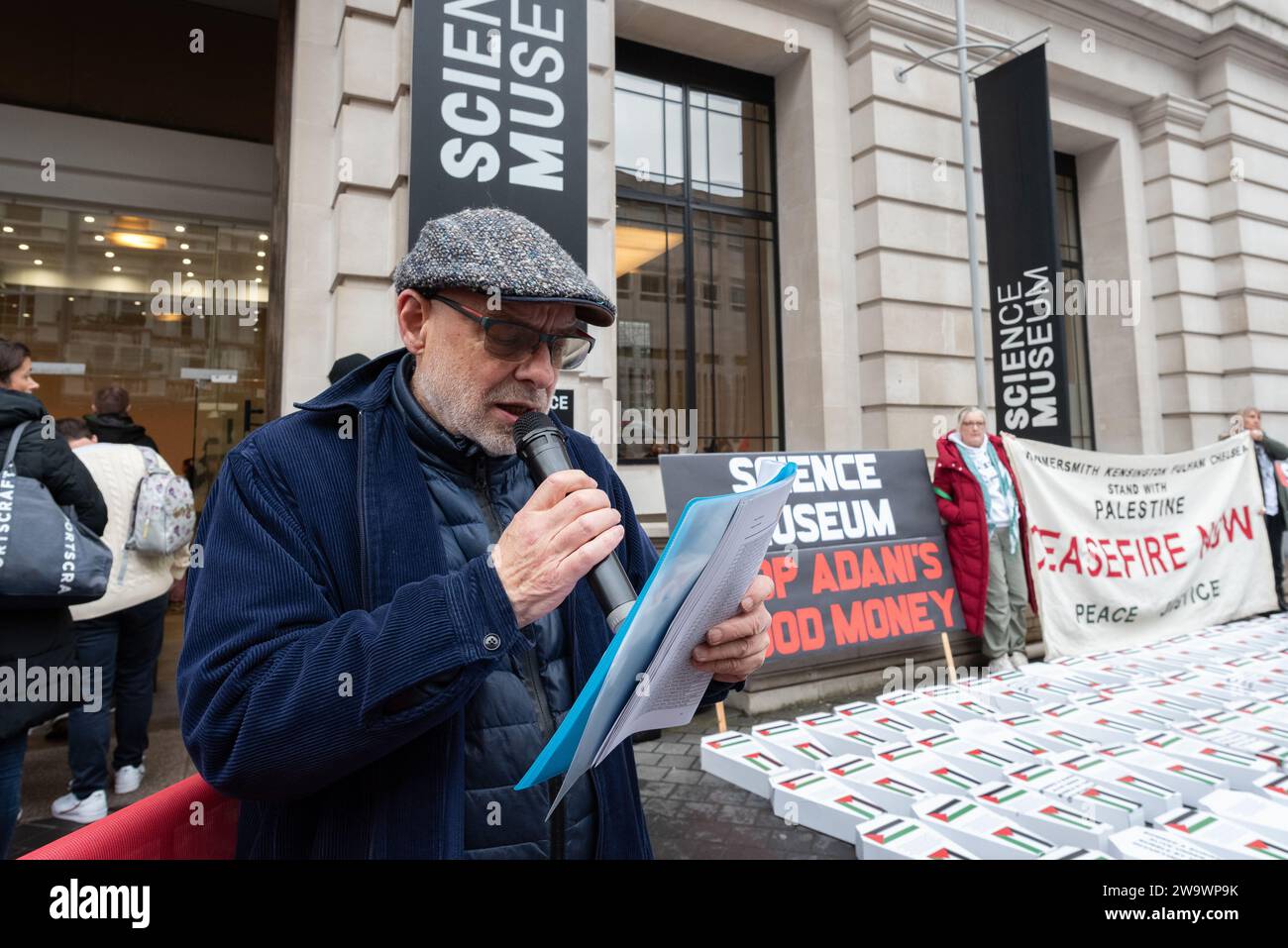 London, UK. 30 December, 2023. Musician and producer Brian Eno reads names of young victims of Israel's war on Gaza during a  protest against sponsorship of the Science Museum's forthcoming 'Energy Revolution' gallery by Indian conglomerate Adani, which manufactures weapons with and supplies arms to Israel. Credit: Ron Fassbender/Alamy Live News Stock Photo