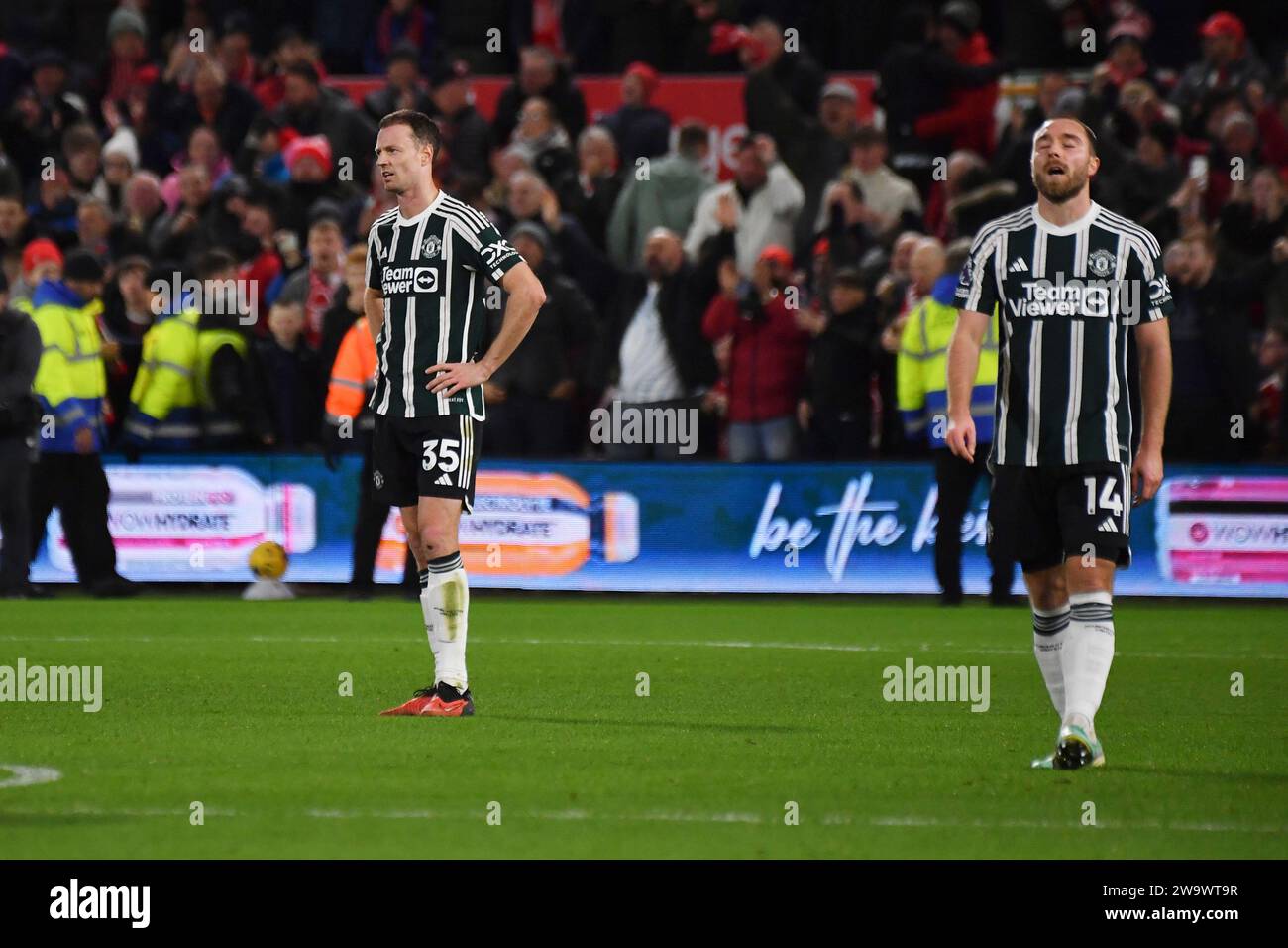 Manchester United's Jonny Evans, left, and Christian Eriksen react after Nottingham Forest's Callum Hudson-Odoi scored his side's second goal during the English Premier League soccer match between Nottingham Forest and Manchester United at City Ground in Nottingham, England, Saturday, Dec. 30, 2023. (AP Photo/Rui Vieira) Stock Photo
