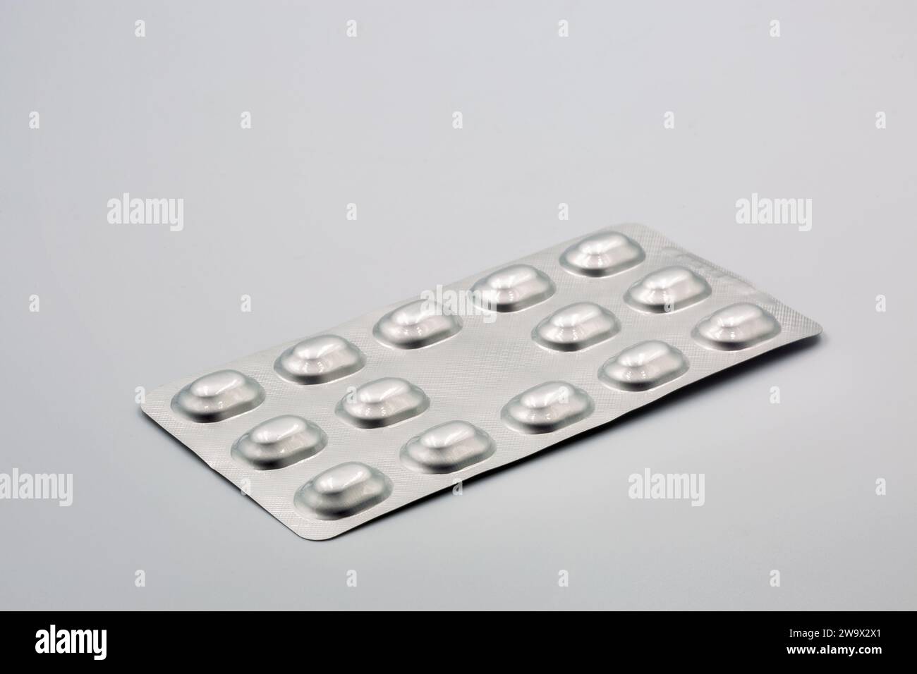 Medical tablets in metal foil blisters closeup against white Stock