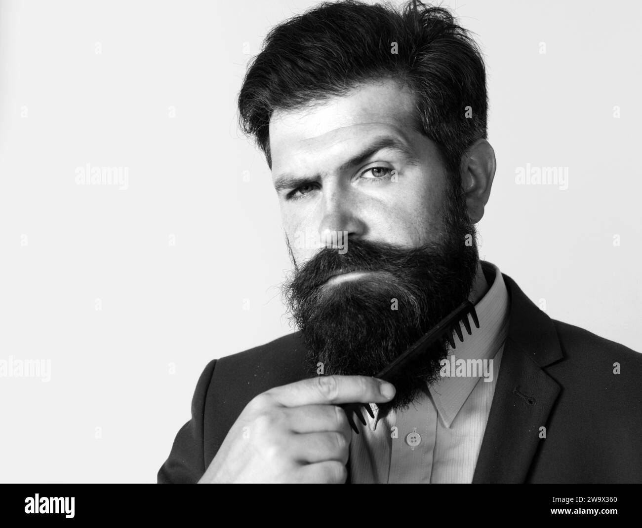 young-man-styling-his-long-beard-with-a-comb-bearded-man-with-beard