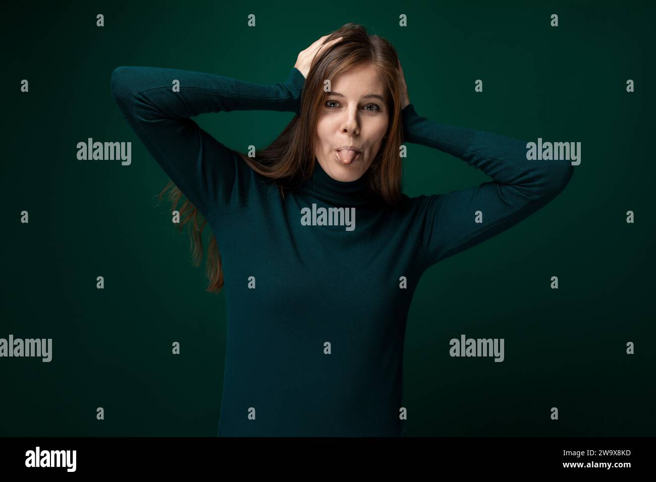 Cute young woman with brown hair wearing a green turtleneck Stock Photo ...