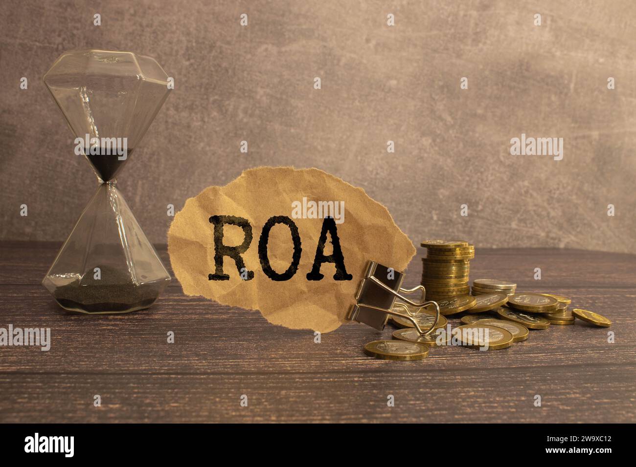 roa - text on wood cube block stack with coins, blue background, business concept. roa - short for Return On Assets. Stock Photo