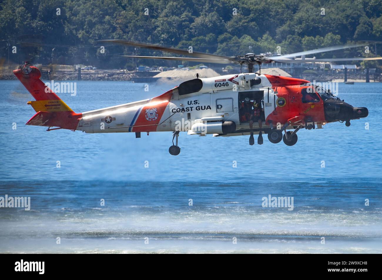 A Coast Guard MH-60 Jayhawk helicopter from Air Station Astoria hovers above the water near Seattle, Wash., Aug. 1, 2023. The demonstration was part of the Parade of Ships for the annual Seafair festival. (U.S. Coast Guard photo by Petty Officer Steve Strohmaier) Stock Photo
