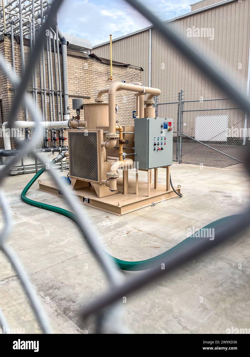 Control unit for an industrial pump station behind a chain link fence ...