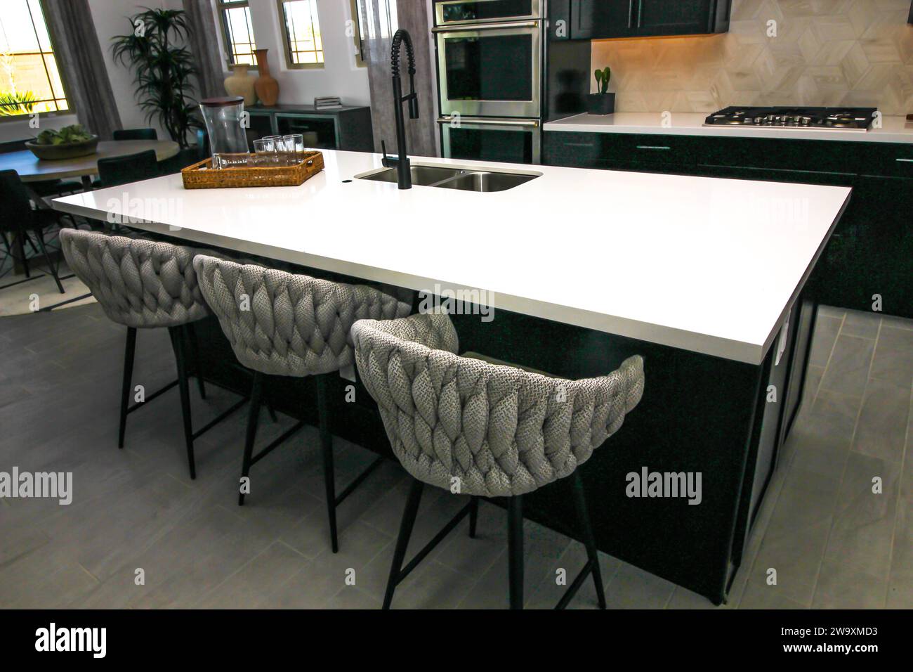 Modern Kitchen Island With Unique Shaped Bar Stools Stock Photo