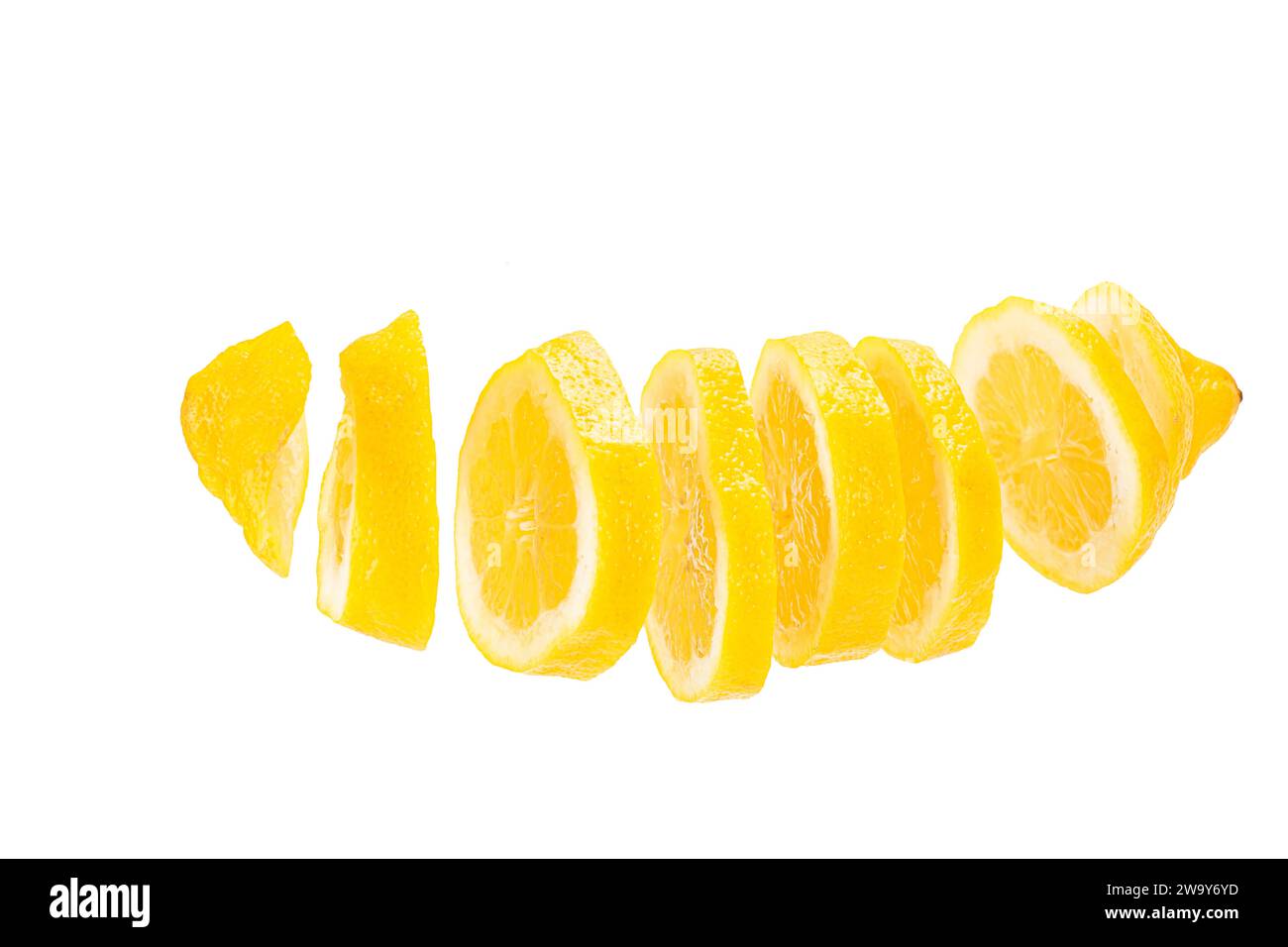Zitrone in Scheiben geschnitten und frei schwebend vor weißem Hintergrund. A lemon cut in slices and placed in a row before a white backdrop Stock Photo