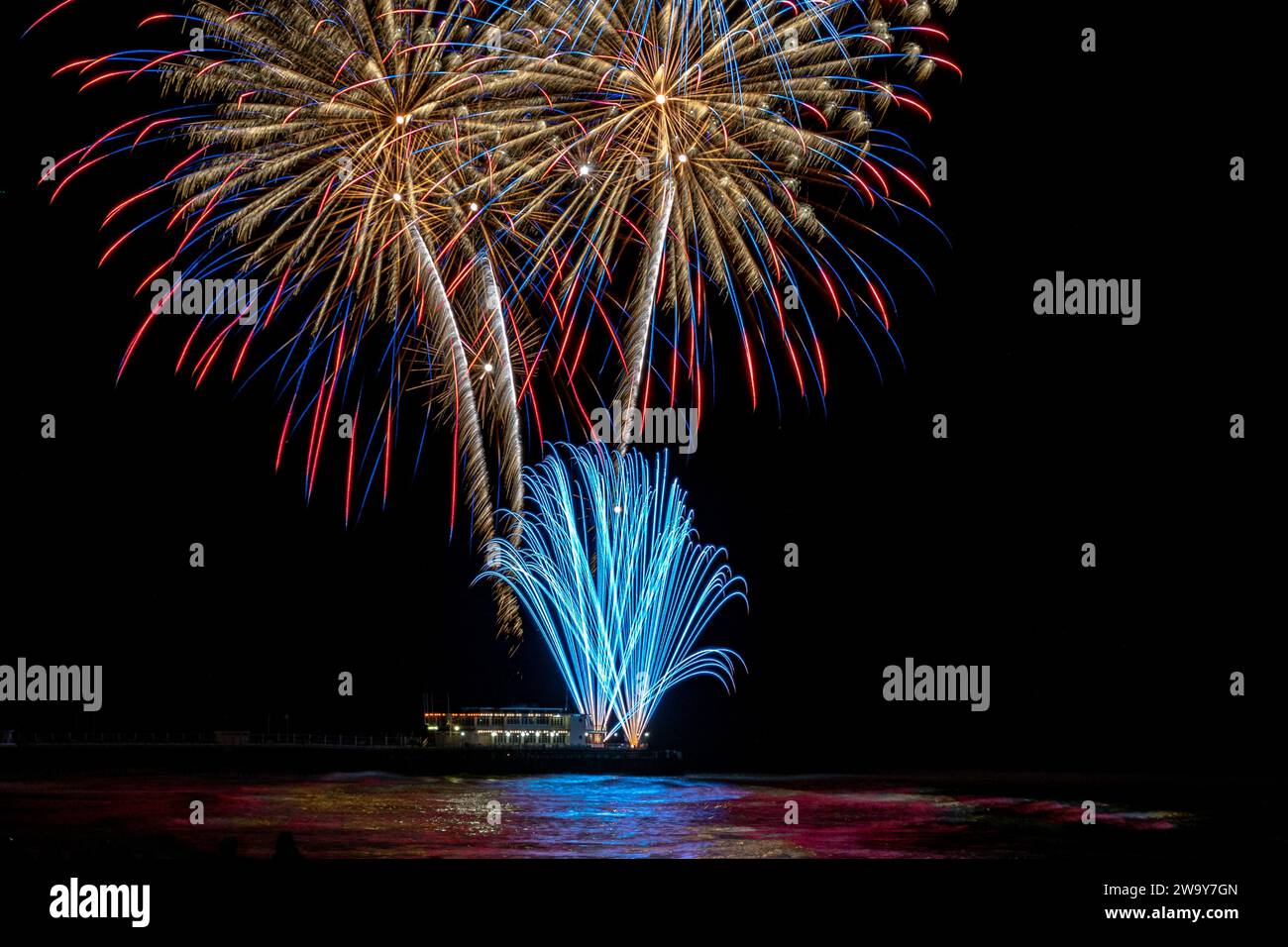 Firework display from a pier over water Stock Photo Alamy