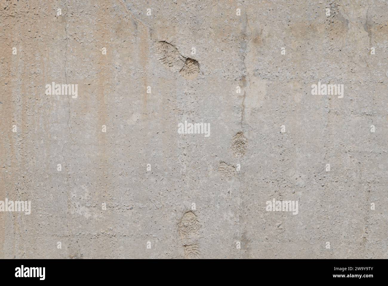 flat gray solid concrete wall with shoe soles imprints, full frame background and texture Stock Photo