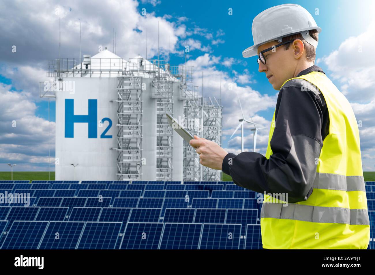 Engineer with tablet computer on a background of Hydrogen factory... Stock Photo