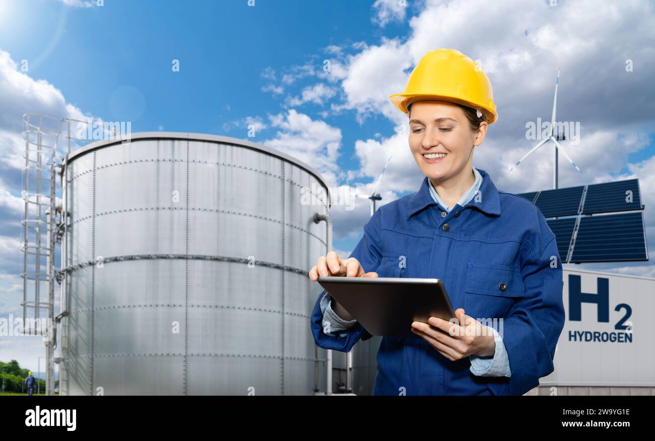 Female engineer with tablet computer on a background of Hydrogen factory. Stock Photo