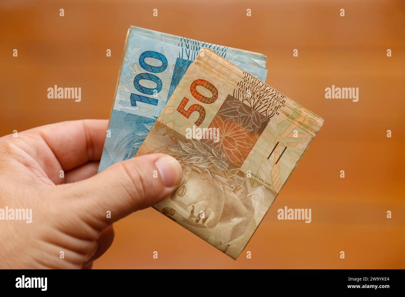 hands delivering money from brazil several hundred bills Stock Photo Alamy