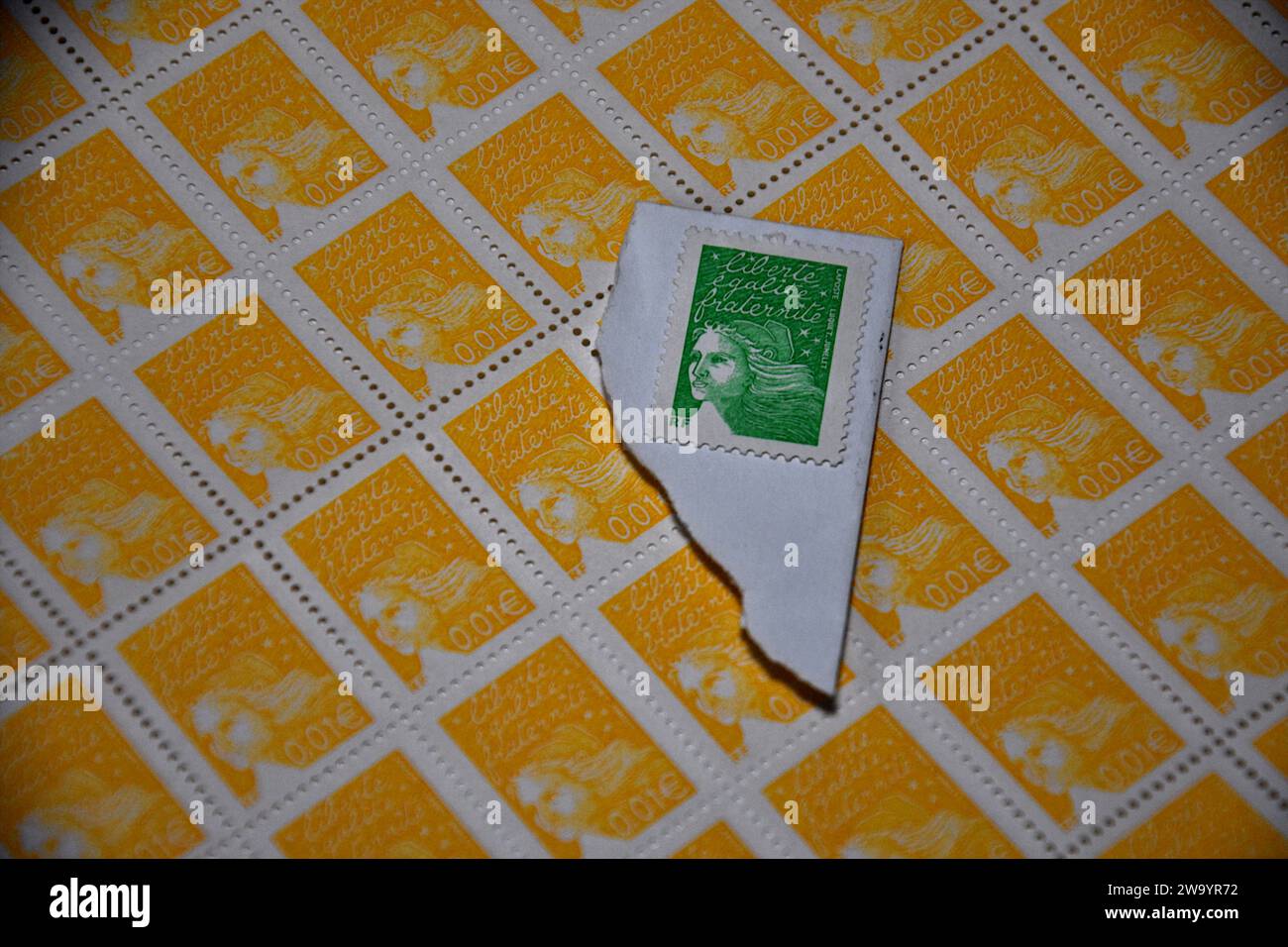 In this photo illustration, a green stamp is placed on a sheet of