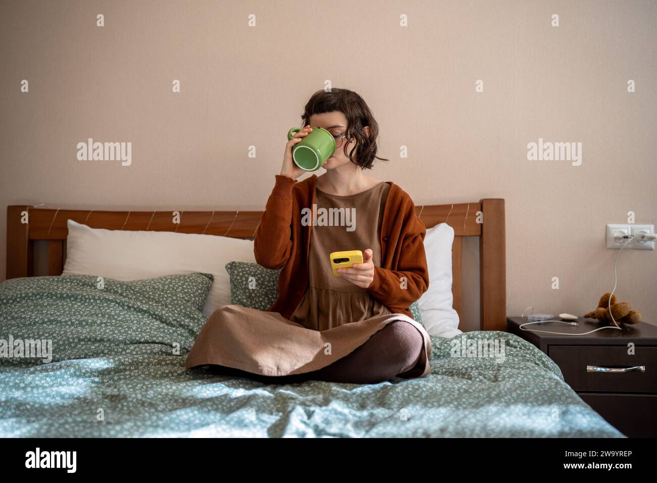 Lazy teenager addicted to internet, smartphone, procrastinating, doing nothing at home, wasting time Stock Photo