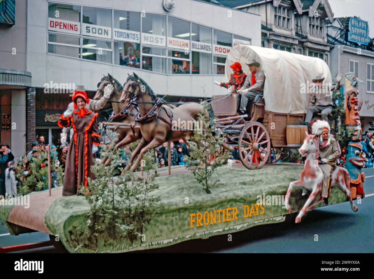 A parade float taking part in Eaton's Santa Claus Parade on Yonge Street, Toronto, Ontario, Canada, November 17, 1962. This float, ‘Frontier Days’, features a wagon and horses, an indigenous native American on horseback and a totem pole. Attracting large crowds, the annual Toronto Santa Claus Parade (also known as The Original Santa Claus Parade) was first held in 1905 and is one of the largest in North America and the oldest Santa Claus parade in the world. It used to terminate at the downtown Eaton's store (later the Eaton Centre) at Yonge Street and Queen Street. Stock Photo