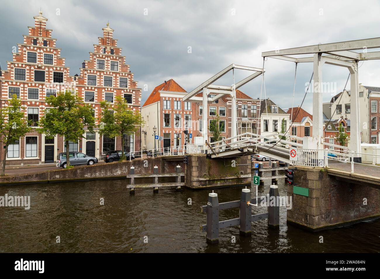 Canal houses on the Spaarne in the center of the historic Dutch city of Haarlem, with the Gravesteen Bridge over the Spaarne in the foreground. Stock Photo