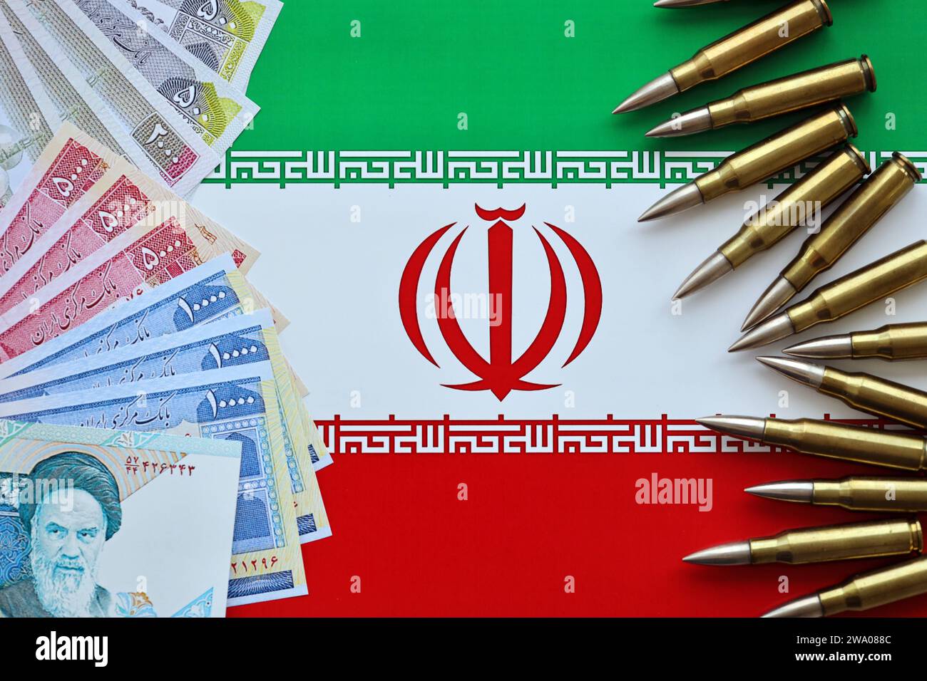 Many bullets and iranian rials money bills on flag of Islamic Republic ...
