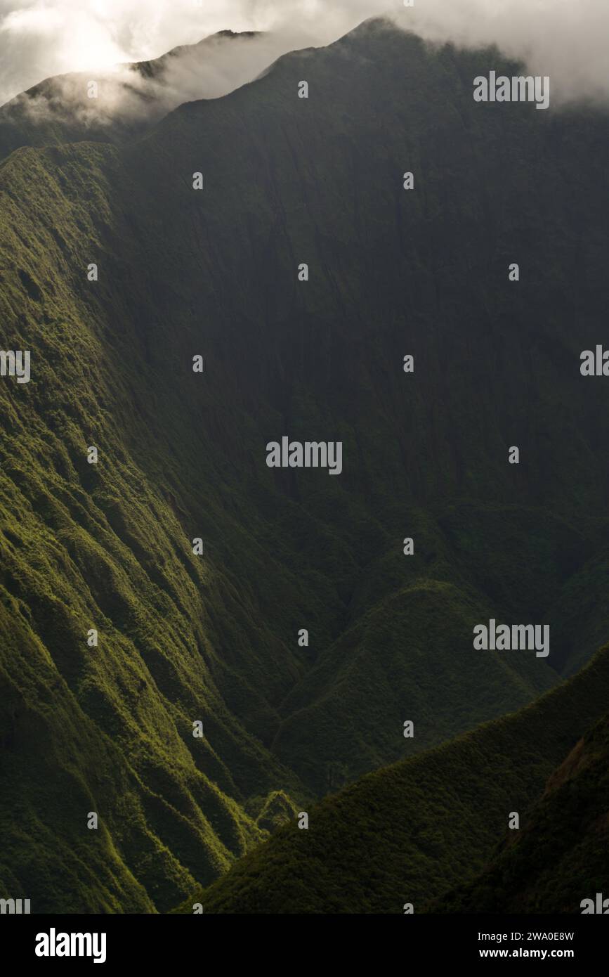 Light cascades down the lush mountain valley of Waihe'e Ridge in Maui ...