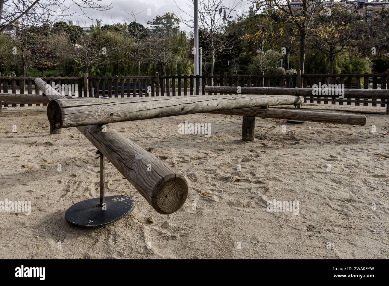 Classic playground equipment made from unvarnished wooden logs and old tires inside a playground in an urban playground Stock Photo