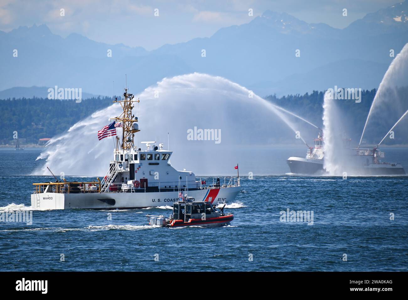 Coast Guard Cutter Wahoo [WPB 87345] and a 29-foot Response Boat-Small transit Elliott Bay near Seattle, Wash., Aug. 1, 2023. A fire boat from the Seattle Fire Department can be seen spraying water from several nozzles as the boats pass by. (U.S. Coast Guard photo by Petty Officer Steve Strohmaier) Stock Photo