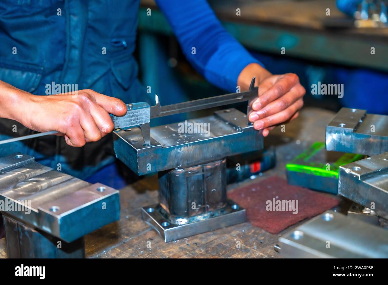 Operator with a cut finger working in a company with milling cutters in a numerical control workshop, high technology through a CNC machining center. Stock Photo