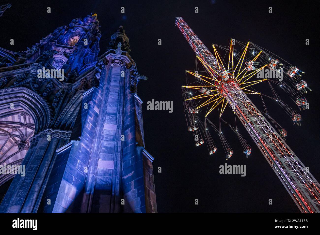 Edinburgh, Scotland, UK, 31st December 2023. Hogmanay New year celebrations: the star flyer fairground ride in Princes Street Gardens next to the Sir Walter Scott monument is a major attraction as midnight approaches. Credit: Sally Anderson/Alamy Live News Stock Photo