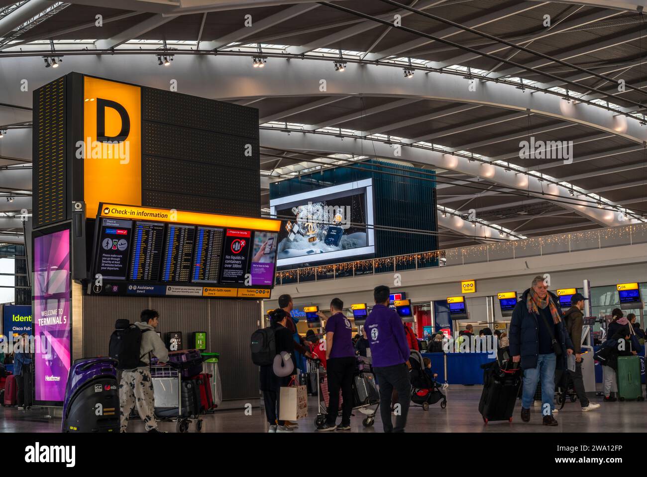 Busy scene with people inside the London Heathrow Airport Terminal 5 building check in area, Heathrow Airport, England, UK Stock Photo