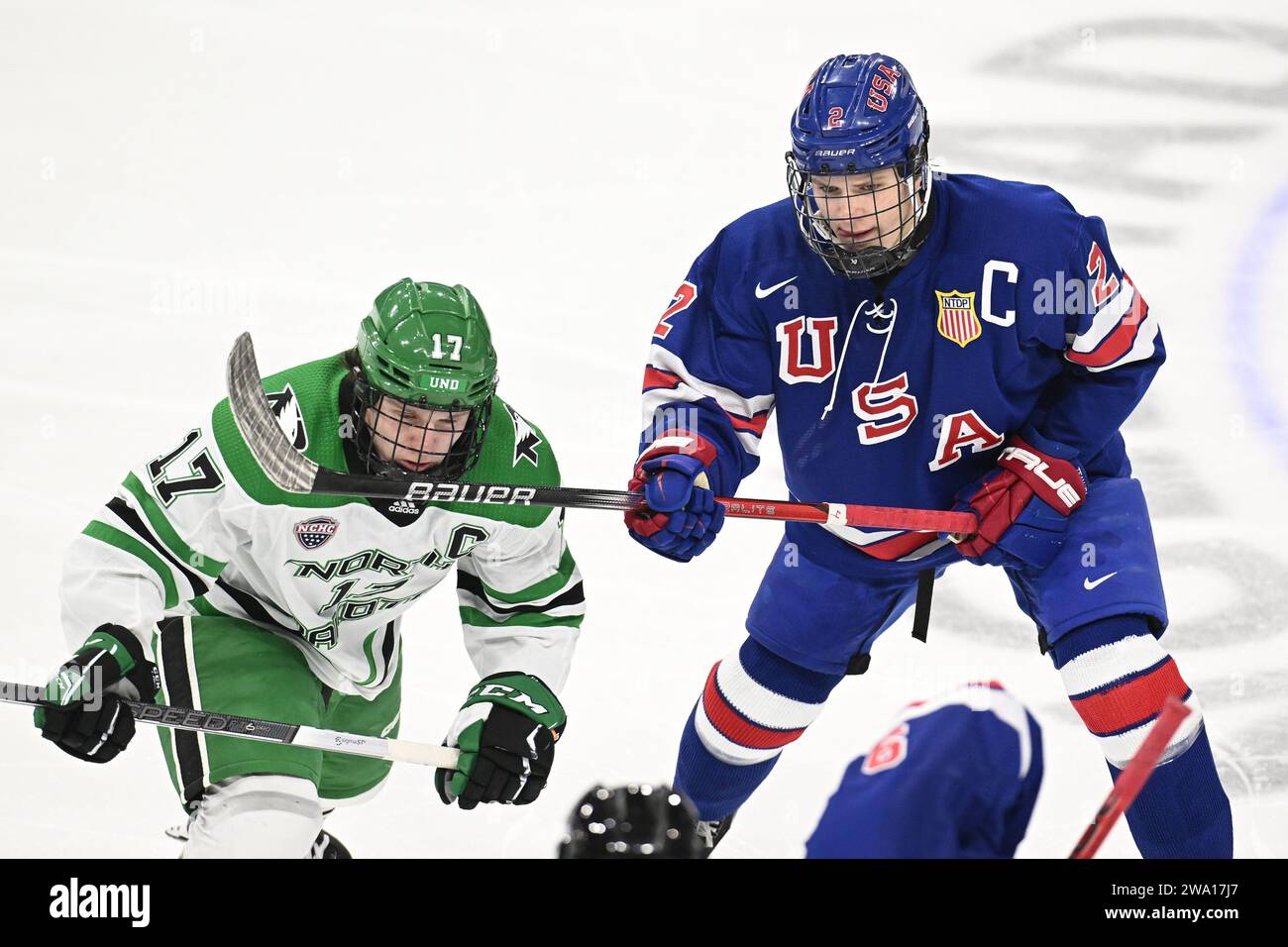 U.S. National U-18 team Brodie Ziemer (2) gets a stick up in front of North Dakota Fighting Hawks Riese Gaber (17) during a faceoff in a NCAA men's college hockey exhibition game between the U.S. National U-18 team and the University of North Dakota Fighting Hawks at Ralph Engelstad Arena in Grand Forks on Saturday, December 30, 2023. USA U18's won 4-3 in overtime. Photo by Russell Hons/CSM (Credit Image: © Russell Hons/Cal Sport Media) Stock Photo