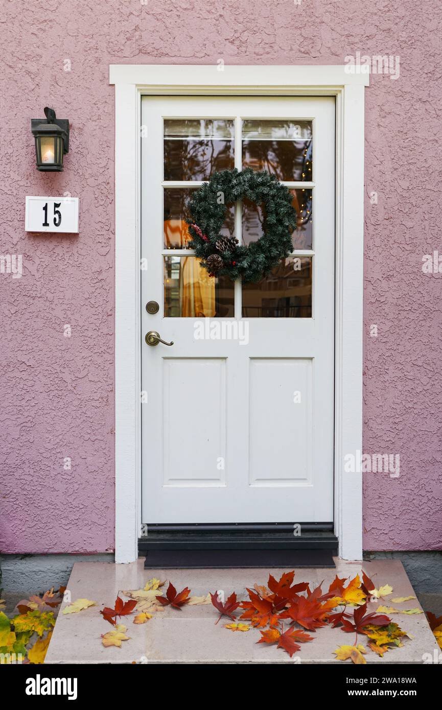 House number 15 with light pink walls and white paneled front door Stock Photo