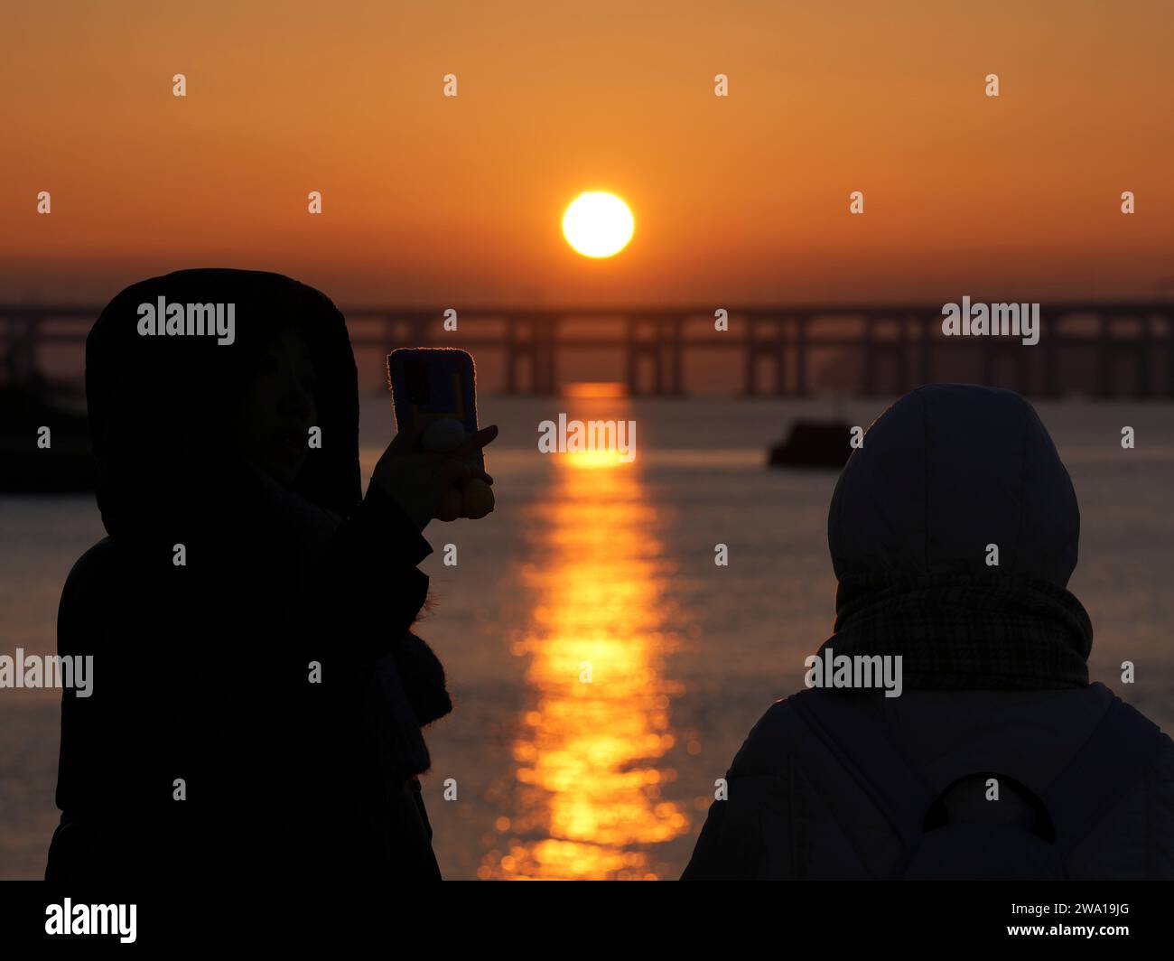 Beijing, China's Liaoning Province. 1st Jan, 2024. People enjoy the sunrise at the Xinghai Square in Dalian, northeast China's Liaoning Province, Jan. 1, 2024. Credit: Li Gang/Xinhua/Alamy Live News Stock Photo