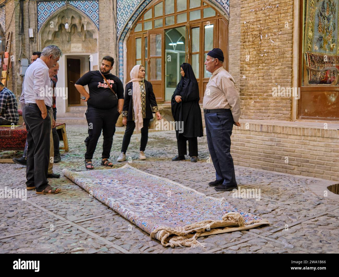 Sellers talk with their customers finalizing sale of an expensive Persian carpet in the Grand Bazaar of Kashan, Iran. Stock Photo