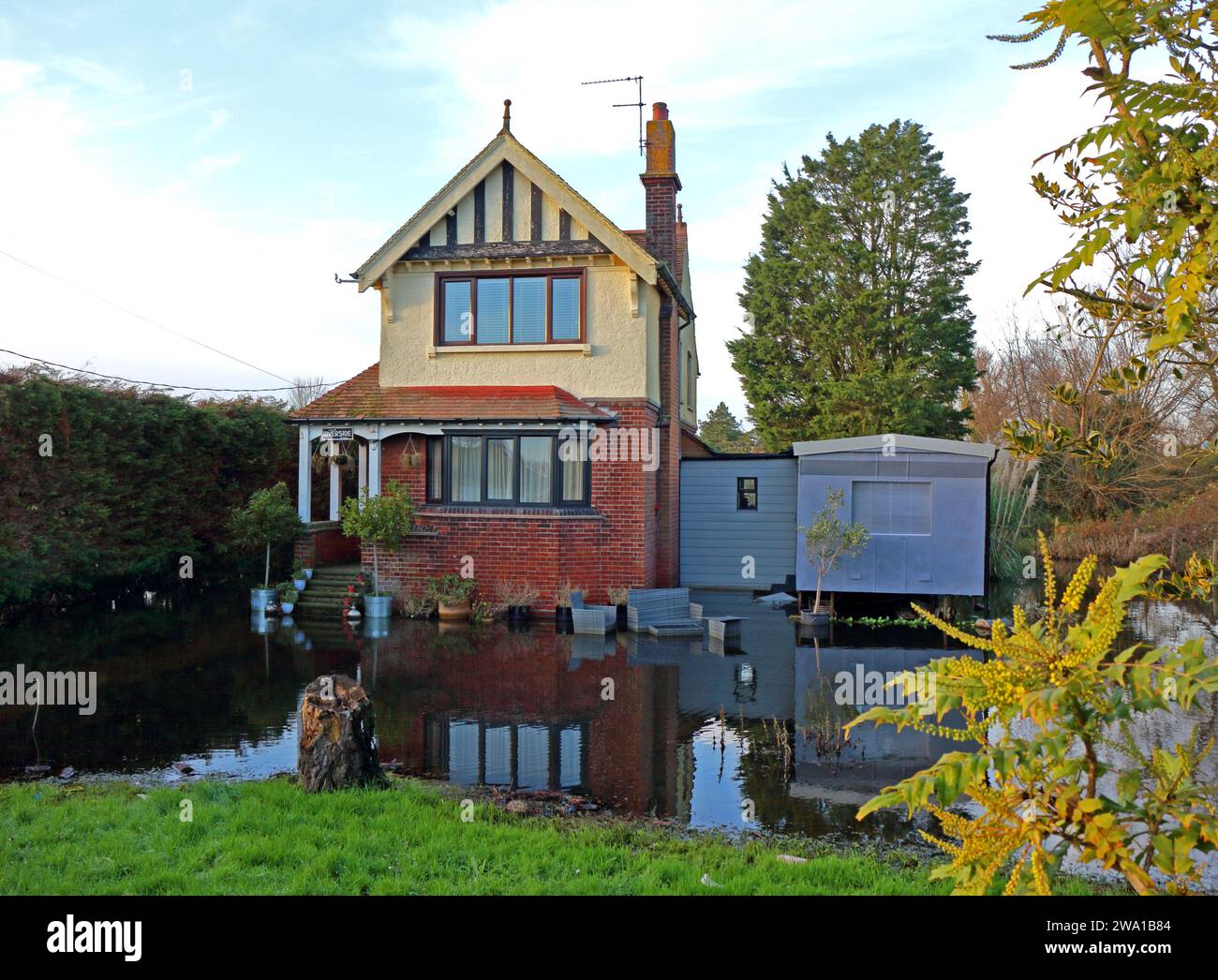 A view of the flooded garden of a property by the River Thurne on the Norfolk Broads after heavy