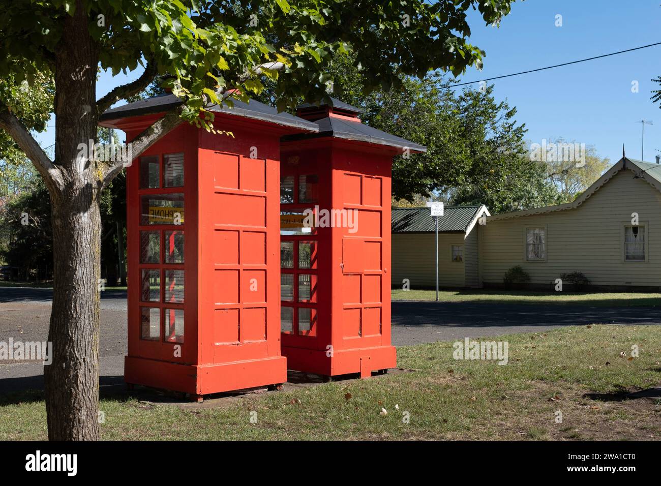 Two old-fashioned red telephone boxes side by side on lawn along a street in Ross, Tasmania Stock Photo