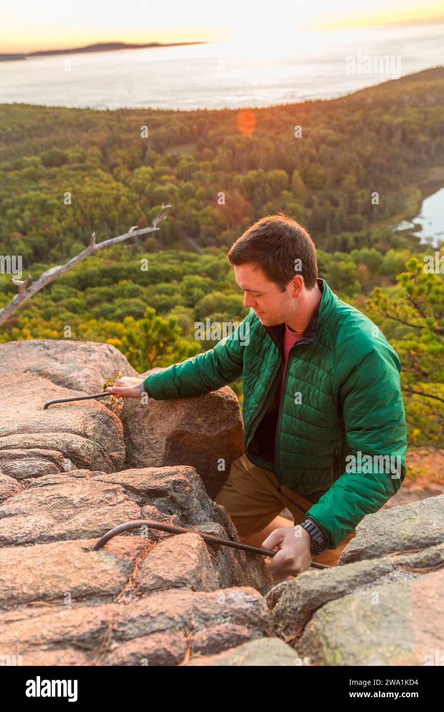 Man hiking Beehive in fall in Acadia National Park, Maine, USA Stock Photo