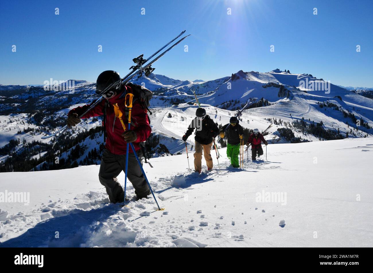 Four skiers hiking up a ridge at a mountain resort near South Lake Tahoe, California. Stock Photo
