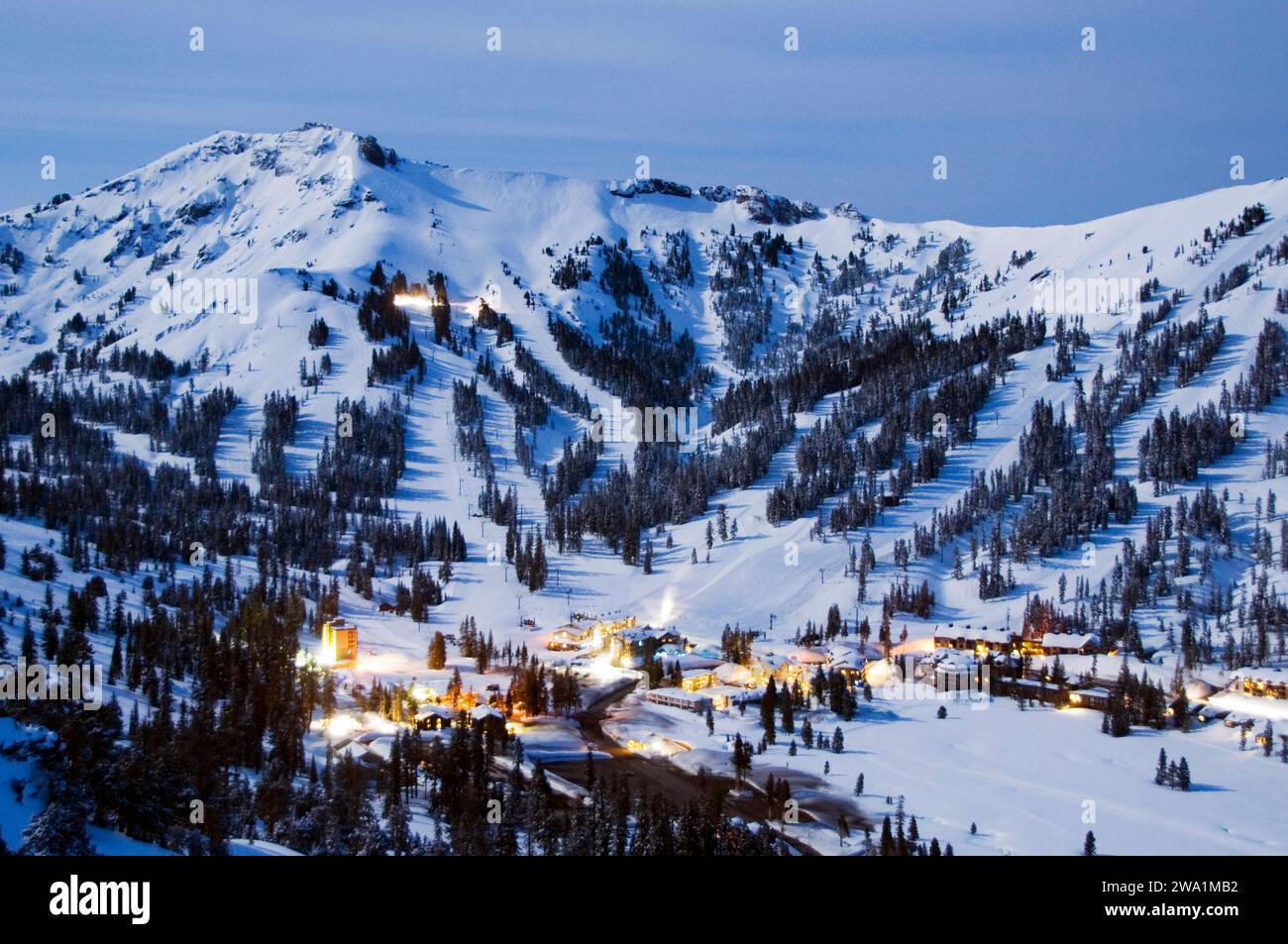 A mountain resort is illuminated by the light from a full moon in the winter, California. Stock Photo