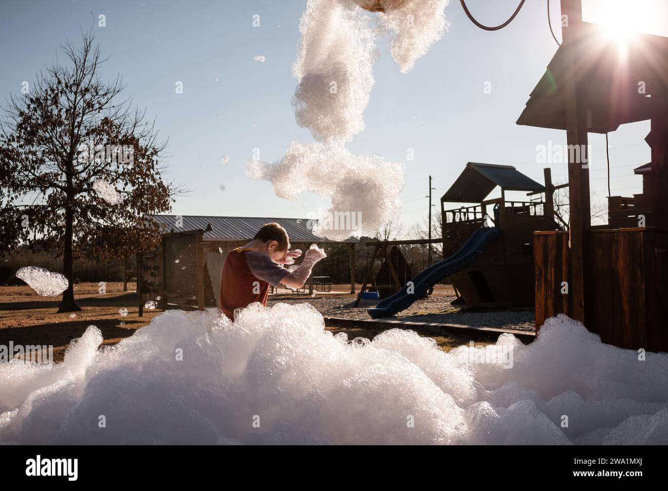 Child playing in foam bubbles at playground Stock Photo