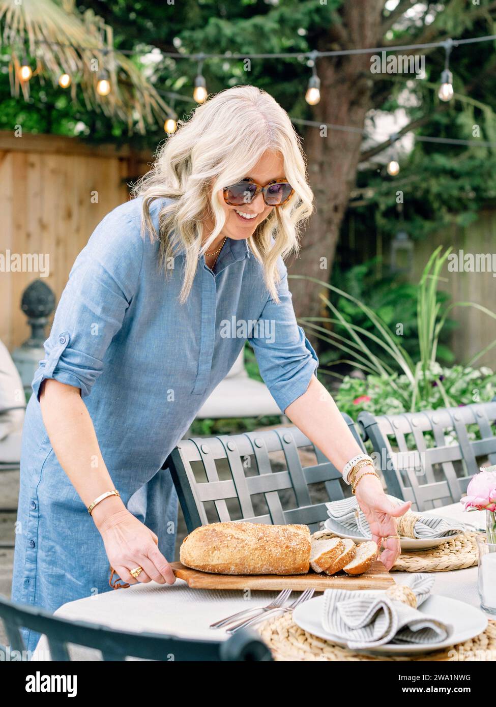 Loving mother setting the table for an outdoor family dinner Stock ...