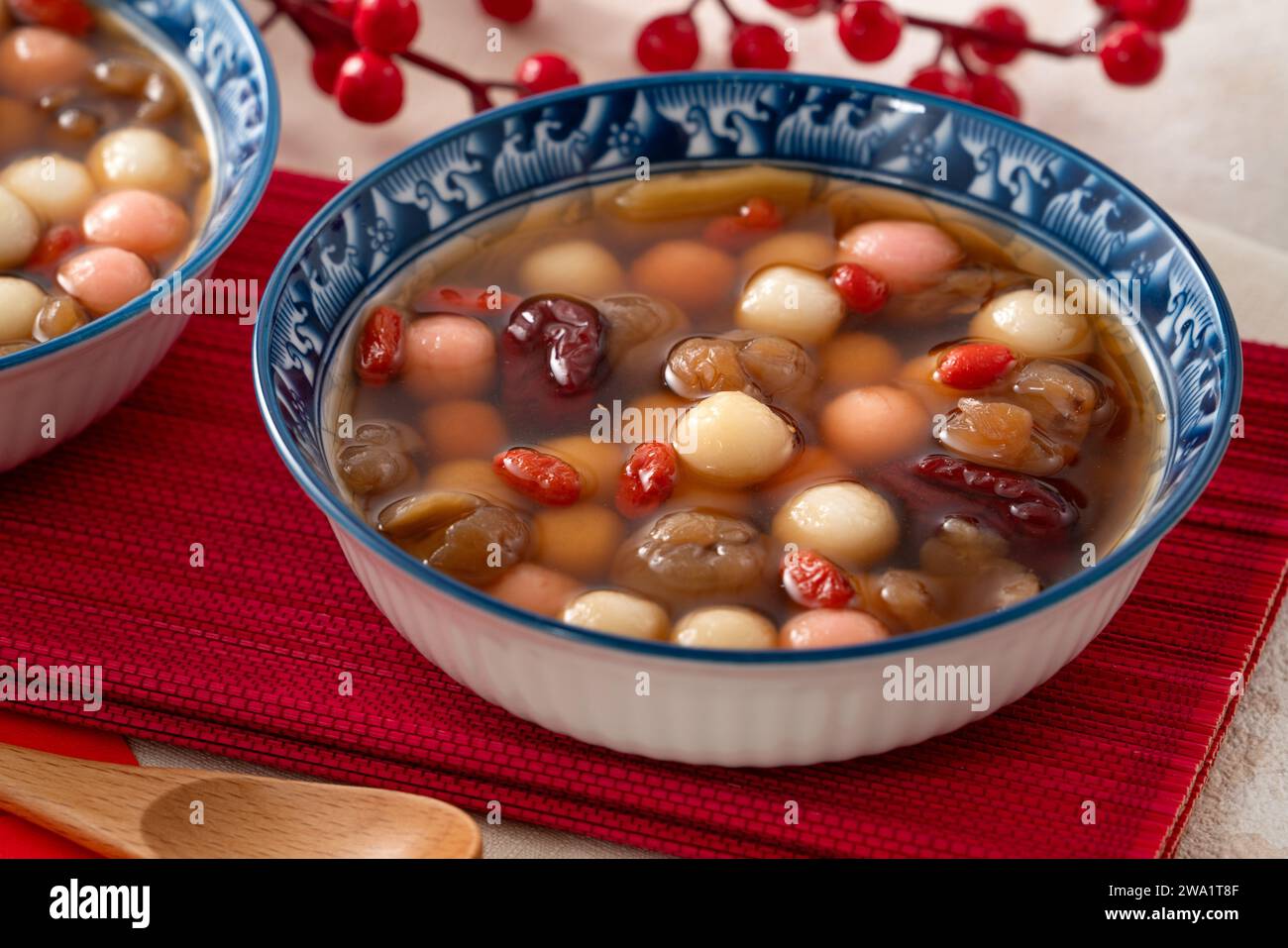 Little homemade red and white tangyuan, tang yuan, rice dumpling balls, with sweet syrup soup and dried longan pulp for Winter solstice festival. Stock Photo