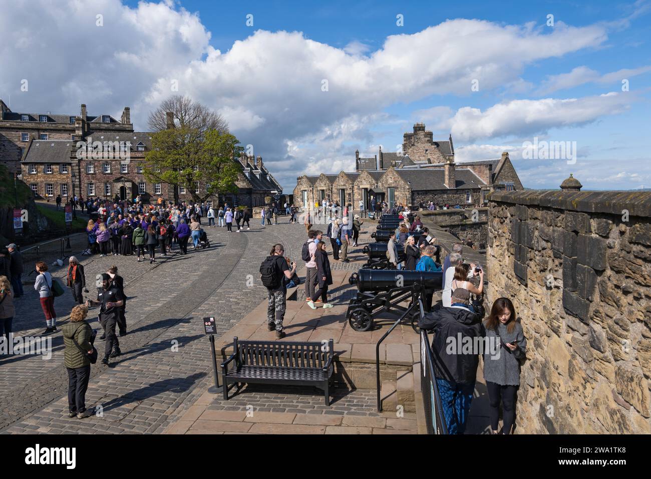 Tourists at the Edinburgh Castle, wall lined with cannons and cobbled road to upper parts of the castle, city of Edinburgh, Scotland, UK. Stock Photo
