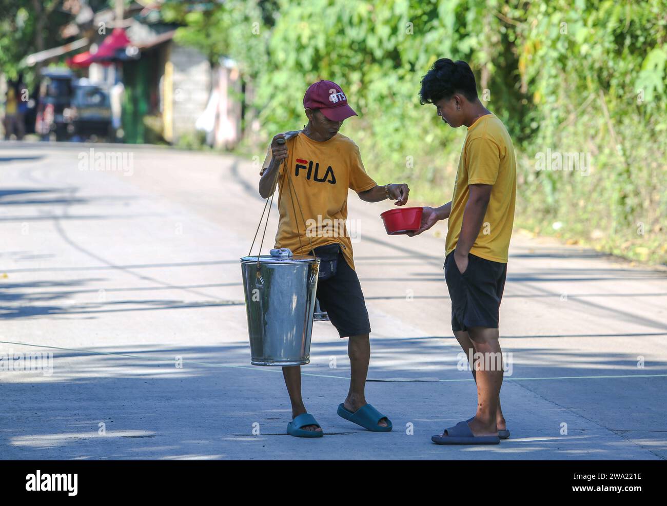 Tiaong, Philippines. 1st Jan 2024: In rural provinces, Filipino poor families setting up friendly toll roads with a rope and a Happy New Year sign. Cars, tricycles or pedestrians are encouraged to make 'thanks giving' donations, generally only a few pesos, without obligation, always with smile and sometimes embellished with few dance steps. A tradition that was practiced only in certain regions and which has spread to almost the entire country since the COVID 19 epidemic hard days. As example, over 1 km, in certain places you can count up to fifteen stops. Credit: Kevin Izorce/Alamy Live News Stock Photo